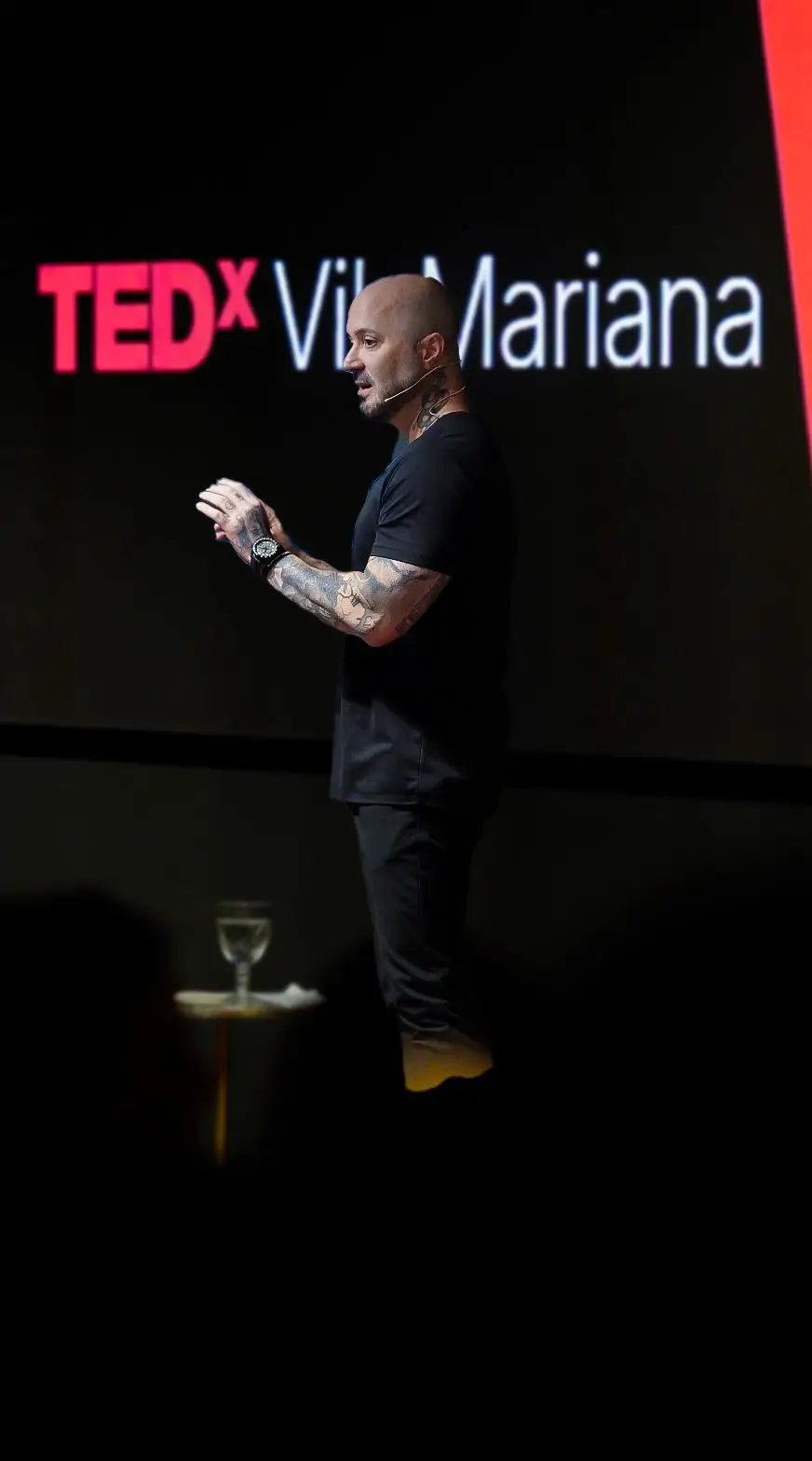 Neto Scardovelli palestrando no palco do TEDx Vila Mariana